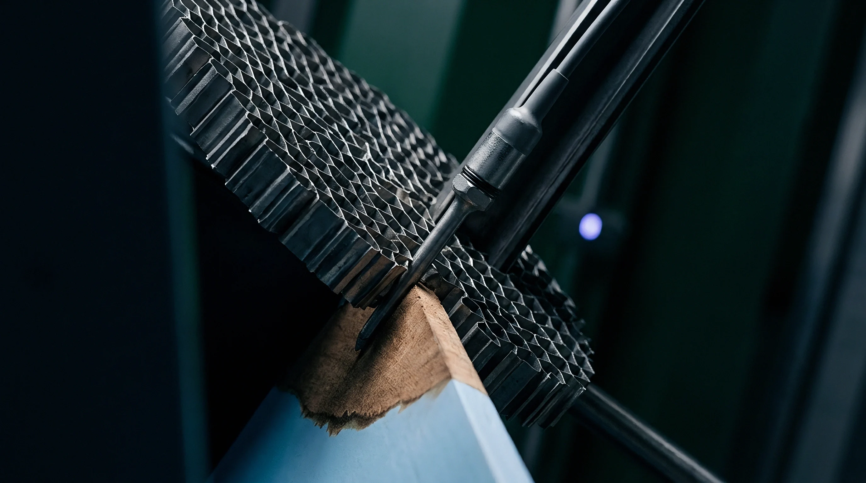 Precision manufacturing equipment positions a metallic honeycomb core during automated assembly of telecommunication hardware components in a production facility.